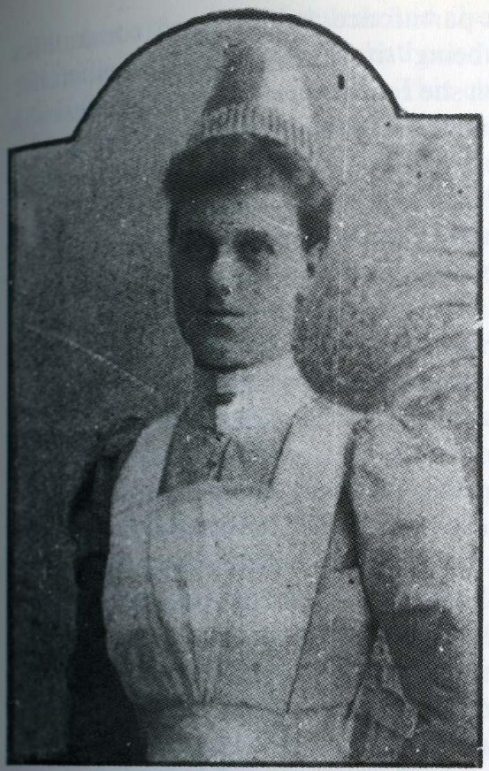 A black and white photograph of a woman in a nursing uniform.